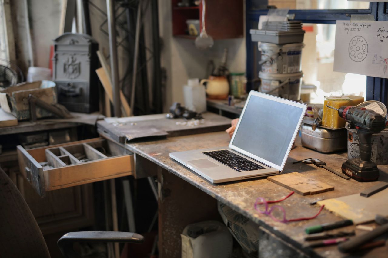 About From above of modern laptop laying at table among different tools and equipment in workshop